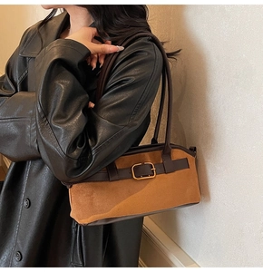 Brown suede shoulder bag with deep coffee leather trim and gold buckle worn by model