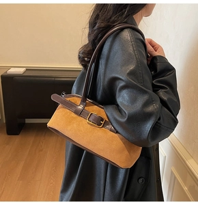 Close-up of vintage brown suede shoulder bag with leather strap and golden metal buckle