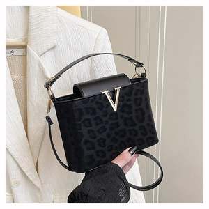 Détail du sac à main noir léopard avec fermoir en métal doré en forme de V élégant
