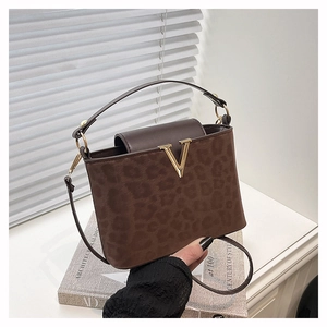 Détail du sac à main léopard avec logo V doré et bandoulière en cuir marron élégant
