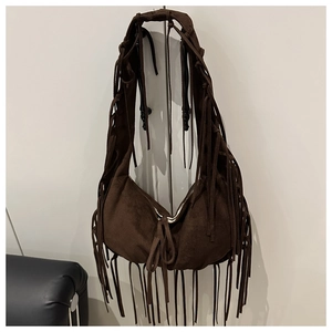 Détail du sac croissant en daim marron foncé avec de longues franges de style bohème