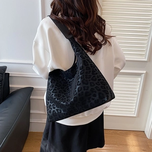 Vintage black leopard print hobo bag with wide shoulder strap shown on female model