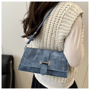 Bolso de hombro azul textura denim con hebilla plateada y detalle de nudo en la correa