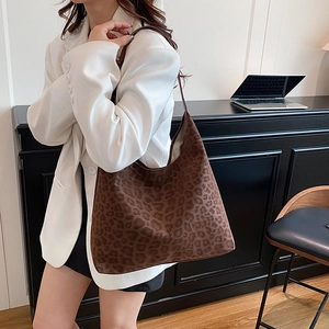 Sac hobo imprimé léopard pour femme porté par un mannequin dans un bureau moderne