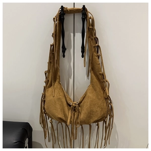 Détail du sac hobo en daim marron avec de longues franges bohèmes suspendues par la poignée