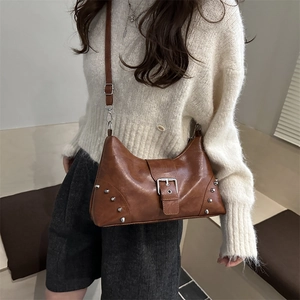 Vintage brown shell-shaped crossbody bag with silver rivet details and adjustable strap