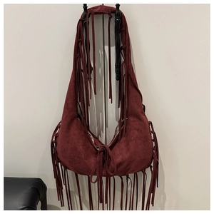 Détail du sac croissant en daim bordeaux avec de longues franges et cordon bohème