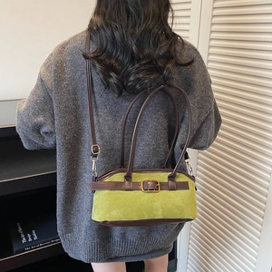 Vintage green suede handbag with brown leather trim and adjustable shoulder strap