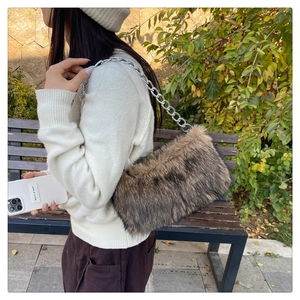 Gros plan d'un sac à bandoulière en fausse fourrure pelucheuse avec une chaîne argentée