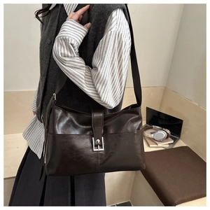 Détail du sac cabas en cuir marron foncé vintage avec boucle et large bandoulière