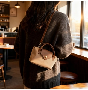Nylon crossbody bag with leather trim shown on model in warm evening sunlight
