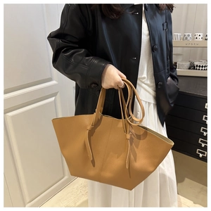 Gros plan d'un grand sac cabas camel en cuir avec structure pliée et poignée nouée