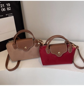 Detail of mini nylon crossbody bags with contrast leather flaps and gold hardware