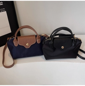 Detail of waterproof nylon mini tote bags with leather trim and detachable cross-body straps
