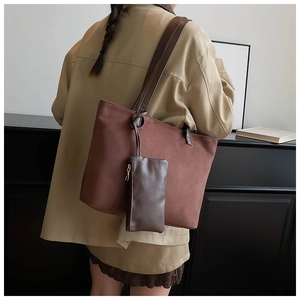 Detail view of brown suede tote bag with matching mini pouch and leather shoulder strap