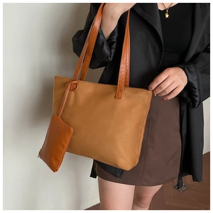 Close-up of a large brown suede tote bag with a matching small hanging zipper pouch
