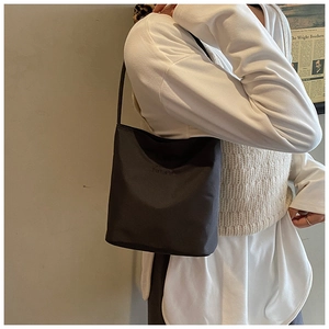Vista laterale dettagliata della borsa a tracolla nera con scritta SUSTAINABLE