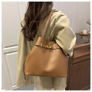 Détail du sac seau en cuir marron avec fermoir doré et cordon de serrage latéral