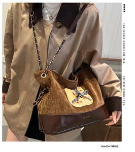 Détail du sac vintage en velours avec patch chat sur un mannequin en trench-coat kaki
