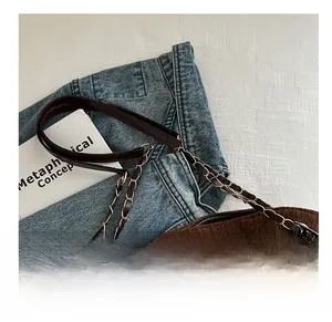 Détail du sac fourre-tout en velours côtelé marron avec chaîne et écussons rétro chic