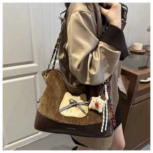 Détail du sac cabas en velours et cuir avec broderie chat et breloque pelucheuse
