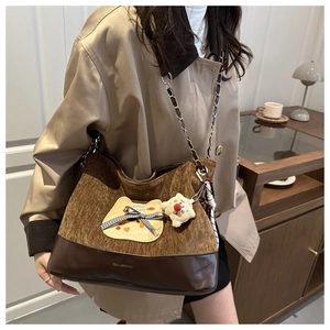 Détail du sac cabas en velours et cuir avec charm peluche et bandoulière chaîne