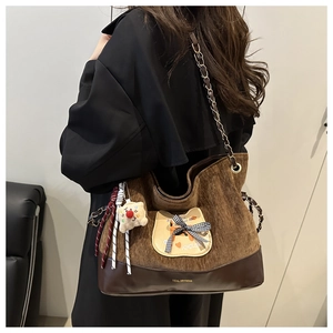 Détail du sac cabas en velours marron avec patch chat et accessoire ours en peluche