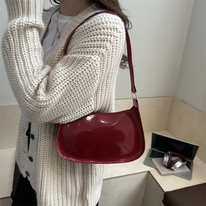 Glossy dark red patent leather baguette shoulder bag with minimalist golden metal buckles