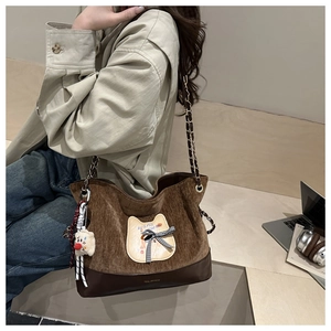 Détail d'un grand sac cabas en velours marron avec écusson chat et chaîne dorée