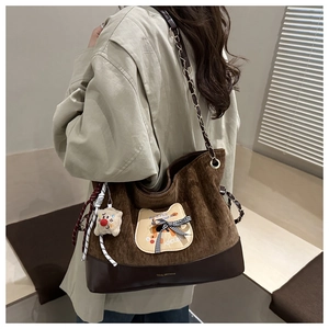 Détail du sac fourre-tout en velours côtelé marron avec écussons d'animaux et peluche épaule