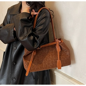 Detail of leopard print tote bag with brown leather straps and plush suede texture
