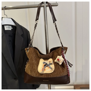 Détail du sac cabas en velours côtelé avec broderie chat et pendentif peluche doux