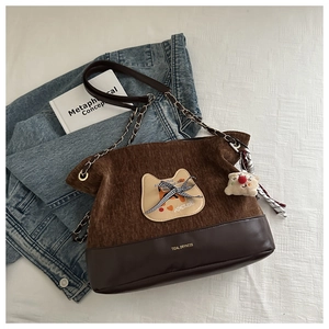 Détail du sac fourre-tout vintage avec patchwork en velours et cuir et emblème chat