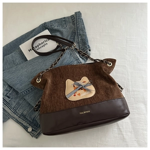 Détail du sac cabas en velours côtelé et cuir avec appliqué chat et bandoulière chaîne