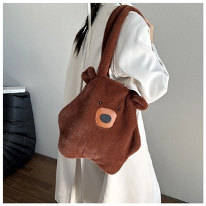 Brown plush bear shoulder bag shown on a model featuring soft faux fur and wide strap