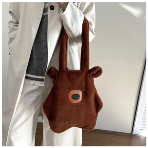 Detail of plush bear tote bag in dark brown with soft texture and cartoon facial features