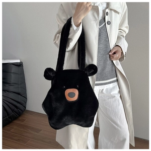 Detail of a black plush teddy bear tote bag showing soft faux fur texture and cute face