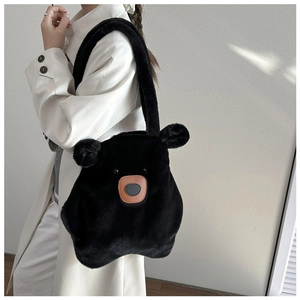 Detailed view of the black plush bear shoulder bag worn by a model in a minimalist setting
