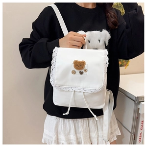 Vue détaillée du sac à dos blanc en similicuir avec bordure dentelle et ourson