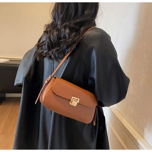 Dettaglio della borsa retrò in pelle caramello con chiusura in metallo dorato lucido