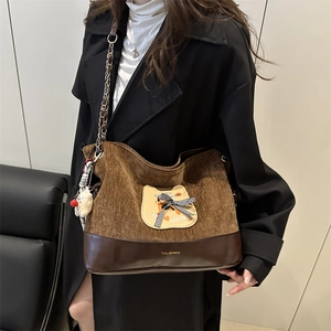 Sac fourre-tout en velours côtelé marron avec patch chat et chaîne porté par un mannequin