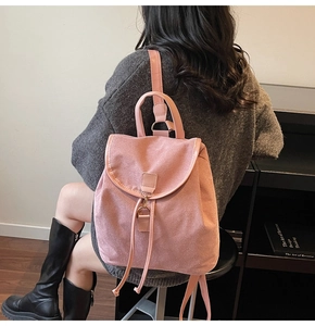 Détail du sac à dos en daim rose montrant le cordon de serrage et les boucles dorées