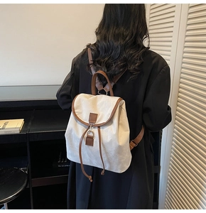 Sac à dos en toile et cuir marron porté par un mannequin dans un décor épuré