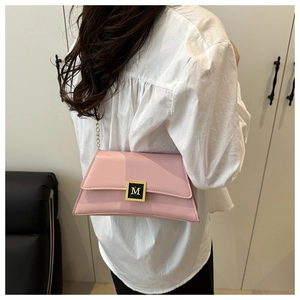 Detail of pink patent leather pillow bag with gold M-logo buckle and metal chain strap