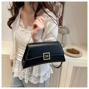 Close-up of black leather shoulder bag featuring a square gold M-letter metal buckle