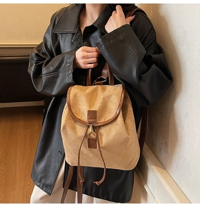 Gros plan du sac à dos en daim kaki avec fermeture à cordon et garnitures en cuir