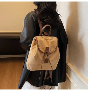 Détail d'un sac à dos en daim kaki avec bordures en cuir marron et crochet en métal