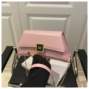 Detail of pink leather envelope bag with gold M buckle and fine stitching craftsmanship