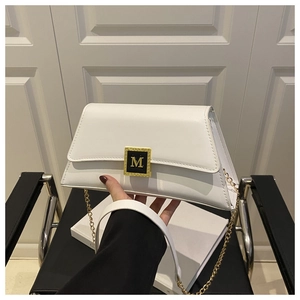 Detail showing white leather handbag with golden M buckle and elegant chain strap texture