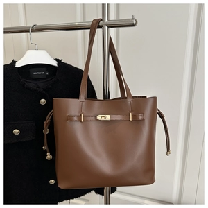 Détails du sac seau marron avec fermoir rotatif doré et cordons de serrage latéraux